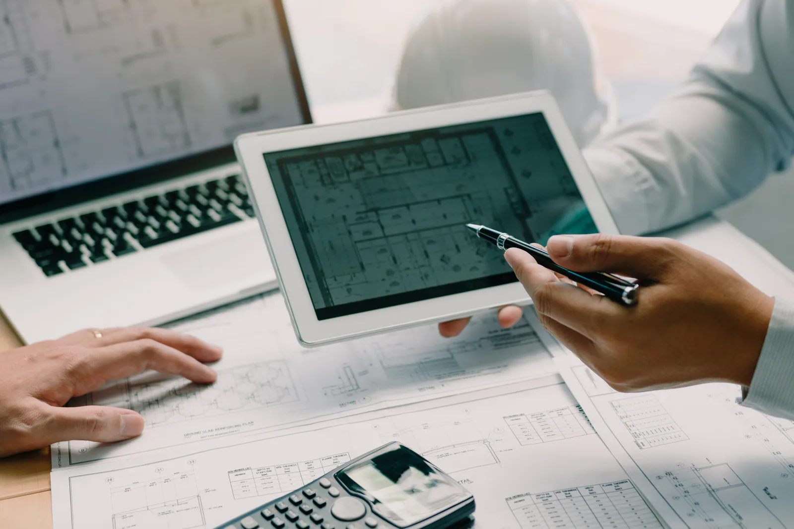 Adviseurs bespreken een technische tekening op een tablet